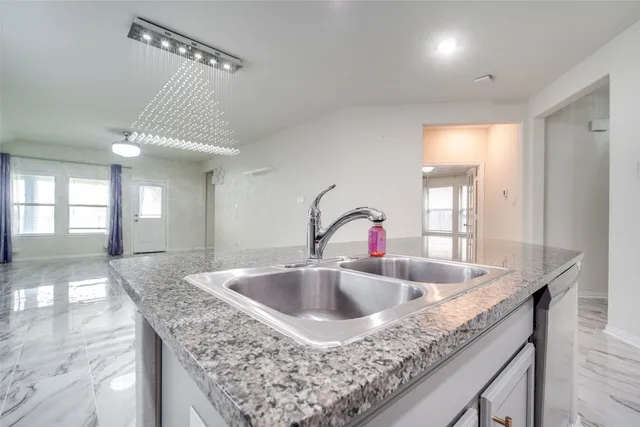 a kitchen with granite countertop a sink and a window