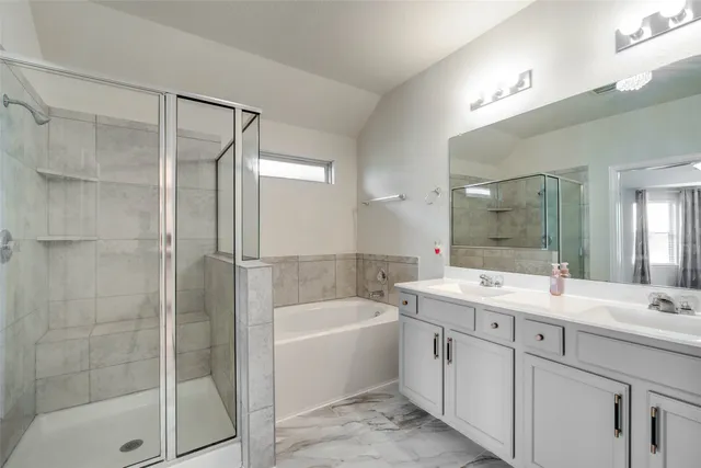 a bathroom with a tub sink mirror and a shower