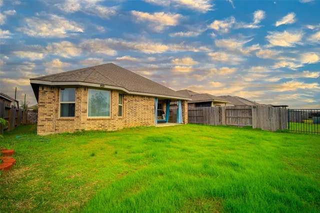 a view of a yard in front of a house with a large tree