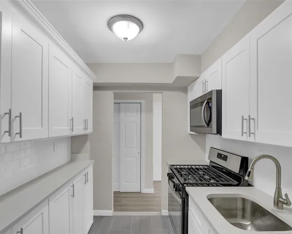 a kitchen with stainless steel appliances granite countertop a sink stove and cabinets