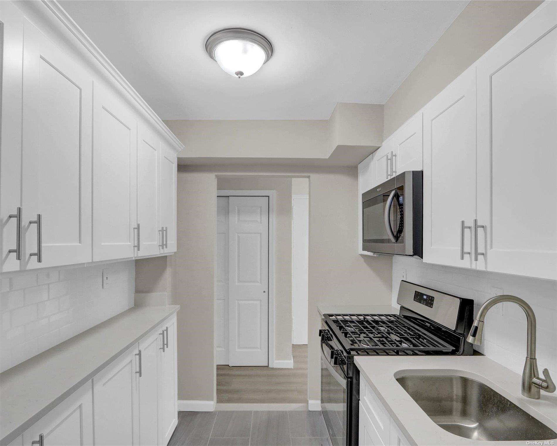 151-31 88th Street, Unit 6H Queens, NY 11414 - Photo 13 of 20 a kitchen with stainless steel appliances granite countertop a sink stove and cabinets