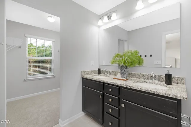 a bathroom with a granite countertop sink a mirror and a window