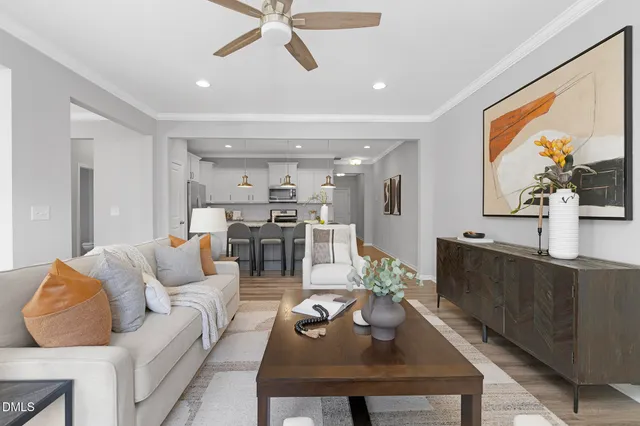 a living room with furniture and a view of kitchen