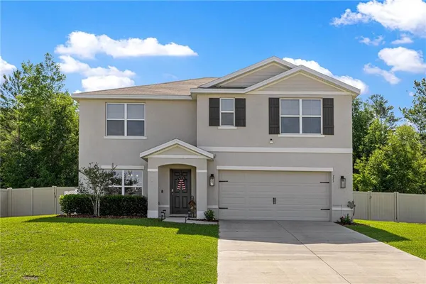 a front view of a house with a yard and garage