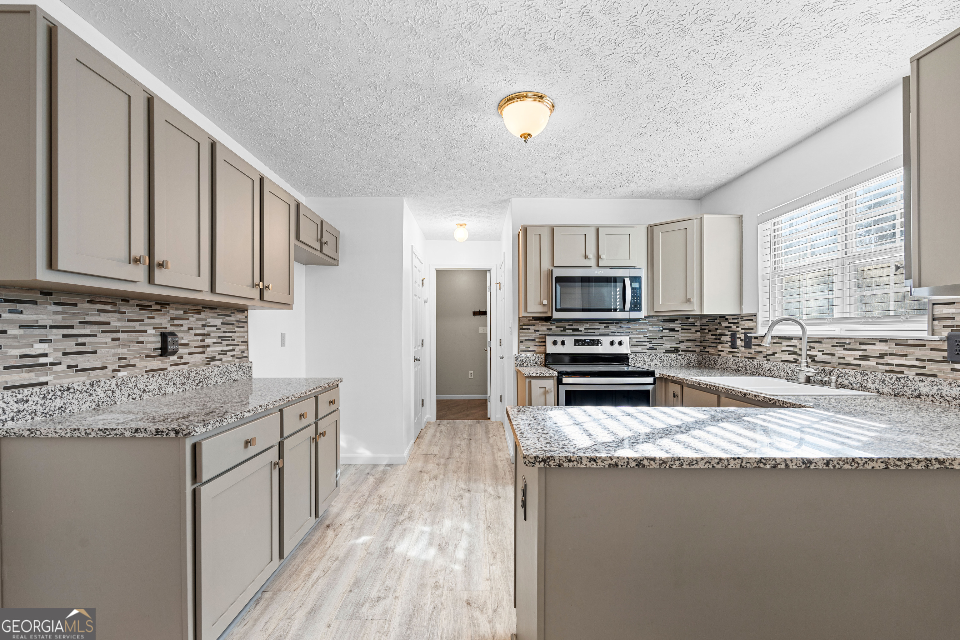 19 Rayner Drive Newnan, GA 30265 - Photo 13 of 53 a kitchen with stainless steel appliances granite countertop a stove a sink and a microwave