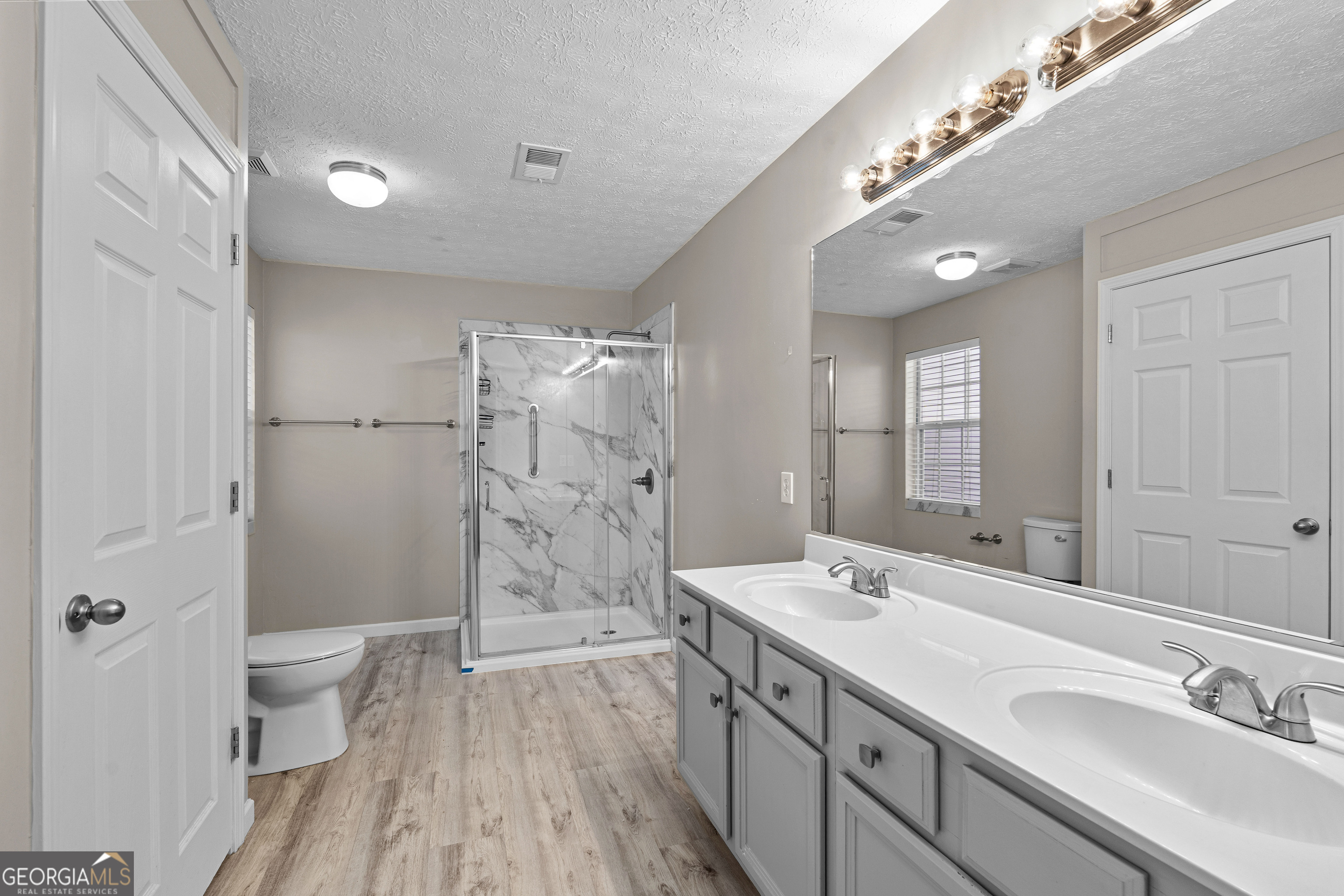 19 Rayner Drive Newnan, GA 30265 - Photo 21 of 53 a spacious bathroom with a double vanity sink a toilet and a shower