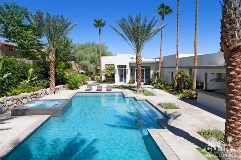 a view of a patio with table and chairs potted plants and palm tree