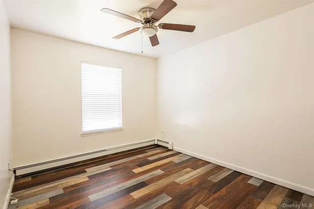 an empty room with a window and a ceiling fan