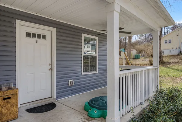 a living room with furniture kitchen view and a wooden floor