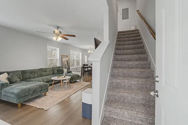 a living room with furniture kitchen view and a flat screen tv