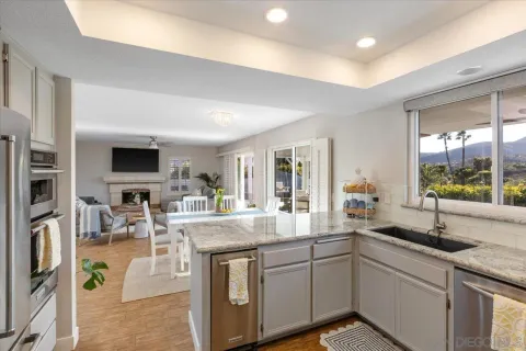 a kitchen with stainless steel appliances granite countertop a sink and a stove