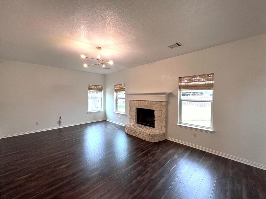306 Howard Way Drive Aledo, TX 76008 - Photo 4 of 23 a view of a livingroom with a fireplace a window and wooden floor