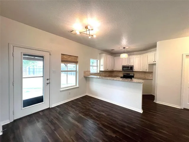 a view of open kitchen with wooden floor and electronic appliances