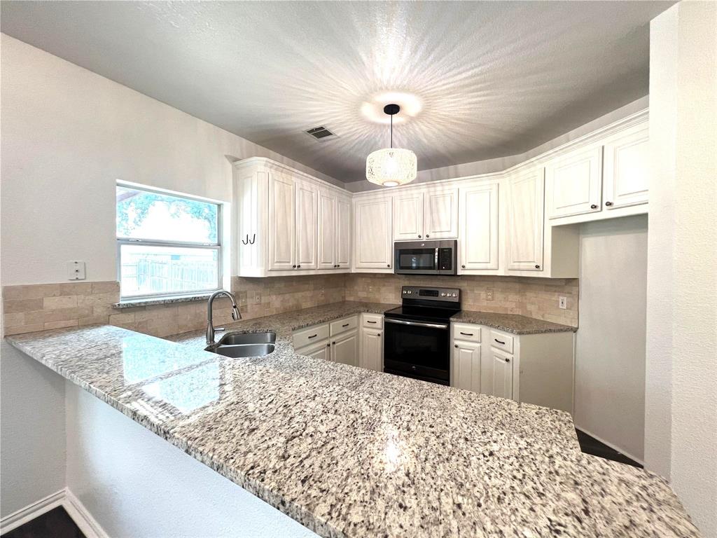 306 Howard Way Drive Aledo, TX 76008 - Photo 7 of 23 a kitchen with granite countertop a sink stainless steel appliances and window