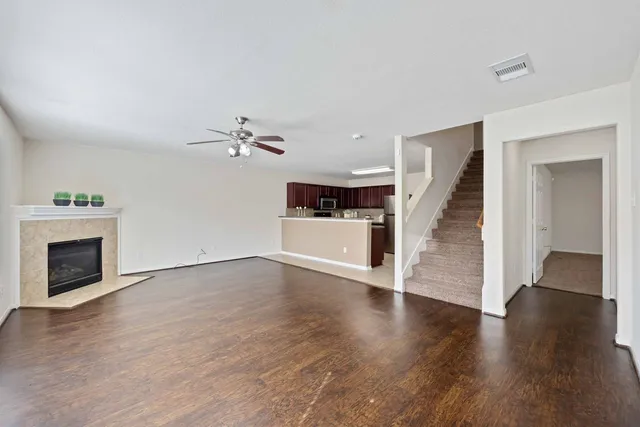 an empty room with windows and chandelier fan