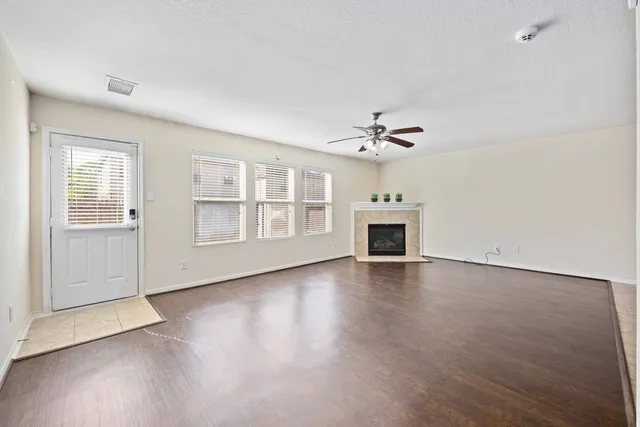 a spacious bedroom with a bed a dresser and potted plants