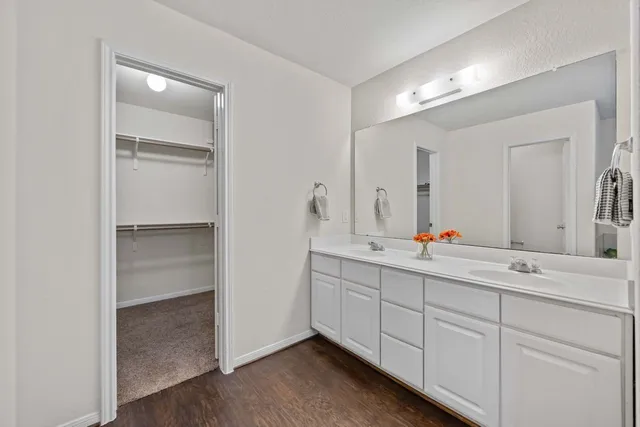 an empty room with a chandelier fan and windows