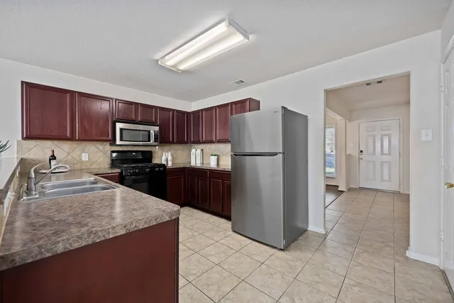 an empty room with wooden floor fireplace and windows