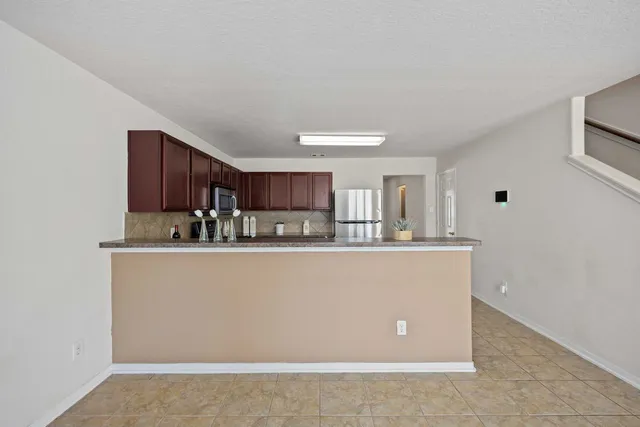 a view of an empty room with wooden floor fireplace and a window