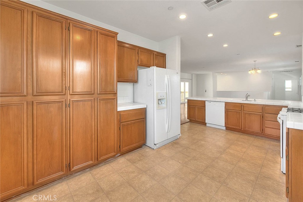 8150 West Preserve Loop Chino, CA 91708 - Photo 24 of 51 a view of a kitchen with a refrigerator a sink and a dishwasher