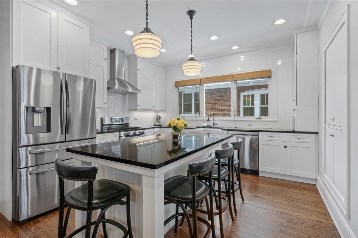 2215 Wesley Avenue Evanston, IL 60201 - Photo 18 of 52 a kitchen with granite countertop a table chairs stove and refrigerator