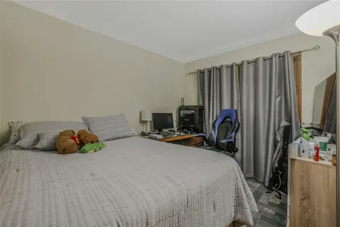 a bedroom with bed a mirror and desk