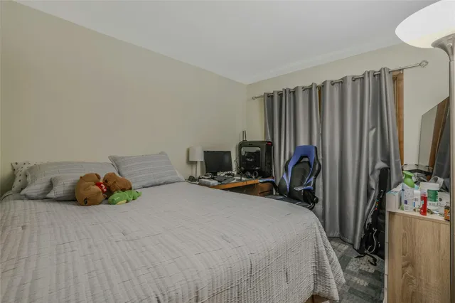 a bedroom with bed a mirror and desk