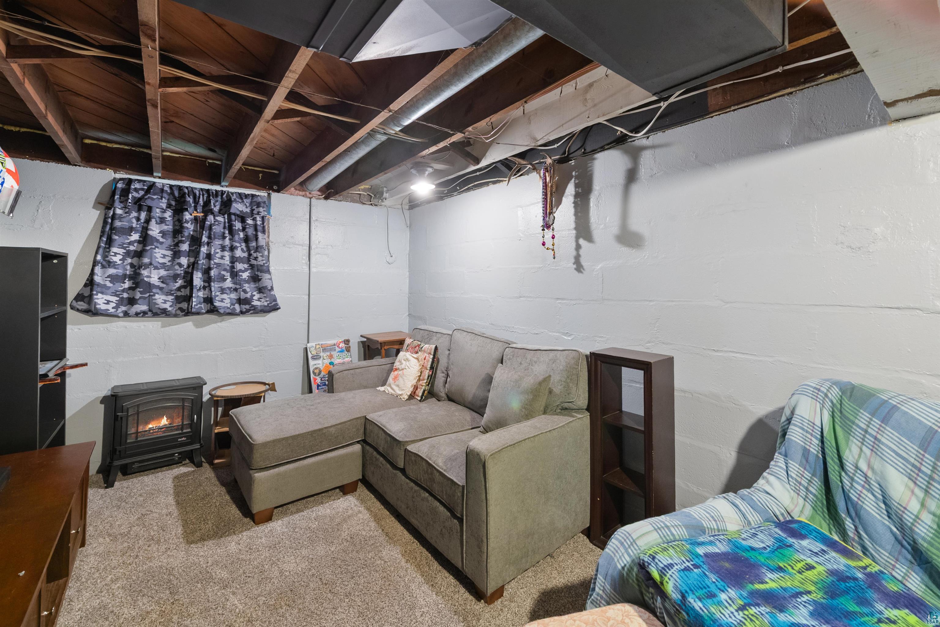 3209 Chestnut Street Duluth, MN 55806 - Photo 18 of 28 Finished lower level with exposed ceiling joists, light gray painted block walls, and a visible window opening