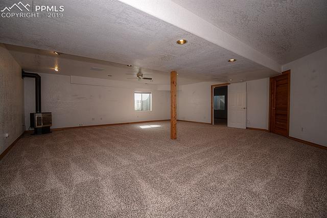 11625 Rex Road Peyton, CO 80831 - Photo 33 of 36 Newly carpeted basement. The free standing gas fireplace is included as is.