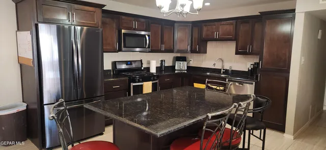 a kitchen with stainless steel appliances granite countertop a sink refrigerator and microwave