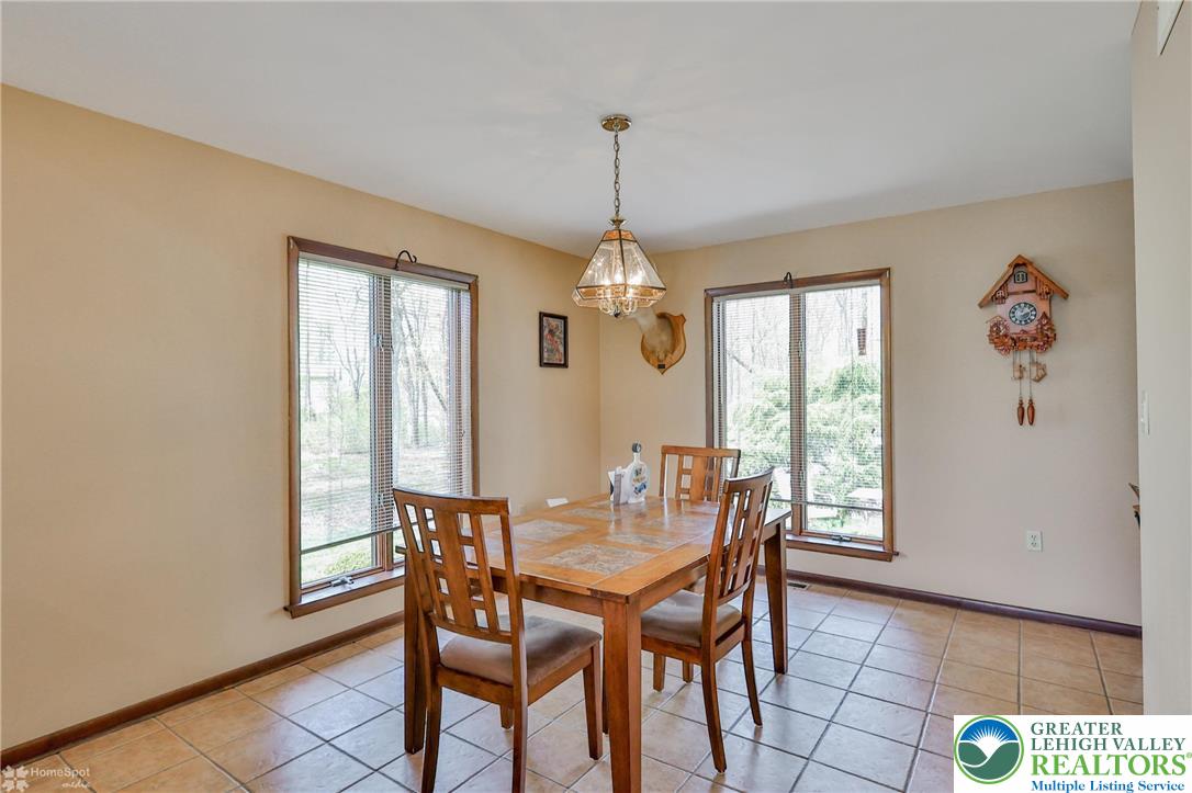 1208 Rone Drive Wind Gap, PA 18091 - Photo 20 of 78 a dining room with wooden floor a chandelier a wooden table and chairs