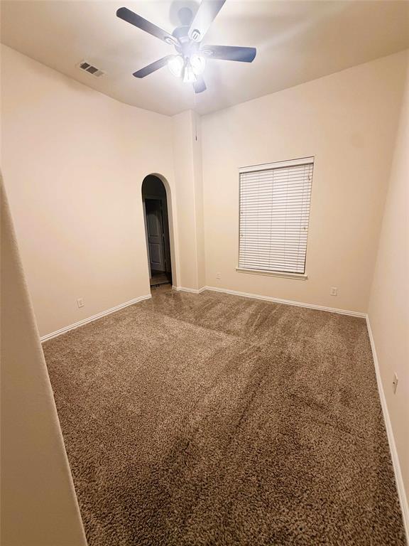 2215 Longview Road Irving, TX 75063 - Photo 20 of 25 Spacious interior room featuring plush brown carpet, high ceilings, and a ceiling fan with integrated lighting
