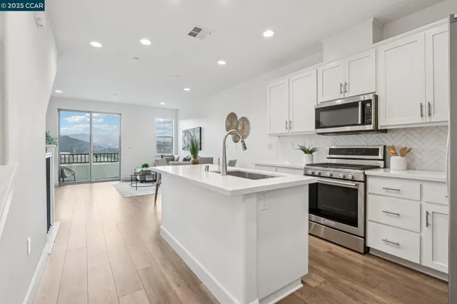 a kitchen with stainless steel appliances granite countertop a stove top oven a sink and a microwave