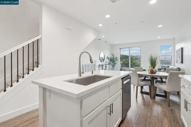 a kitchen with a sink and stove with wooden floor