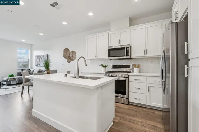 a kitchen with appliances a sink and cabinets
