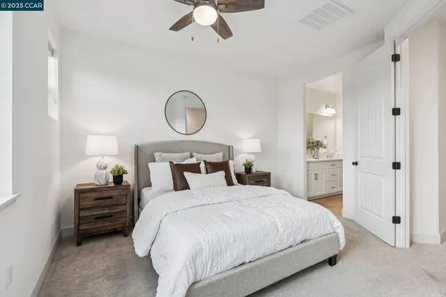 a bedroom with bed and white cabinets