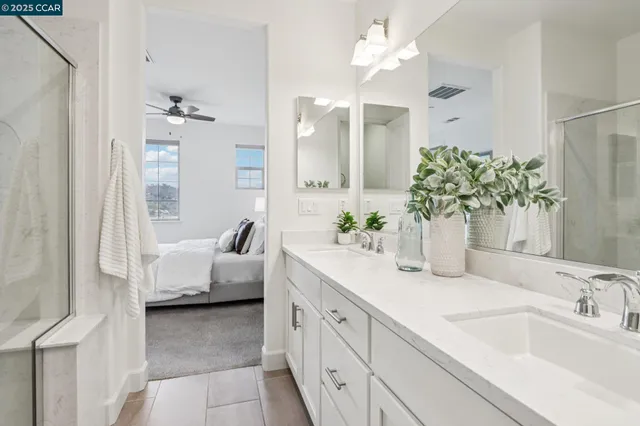 a spacious en suite bathroom with a granite countertop sink and a mirror
