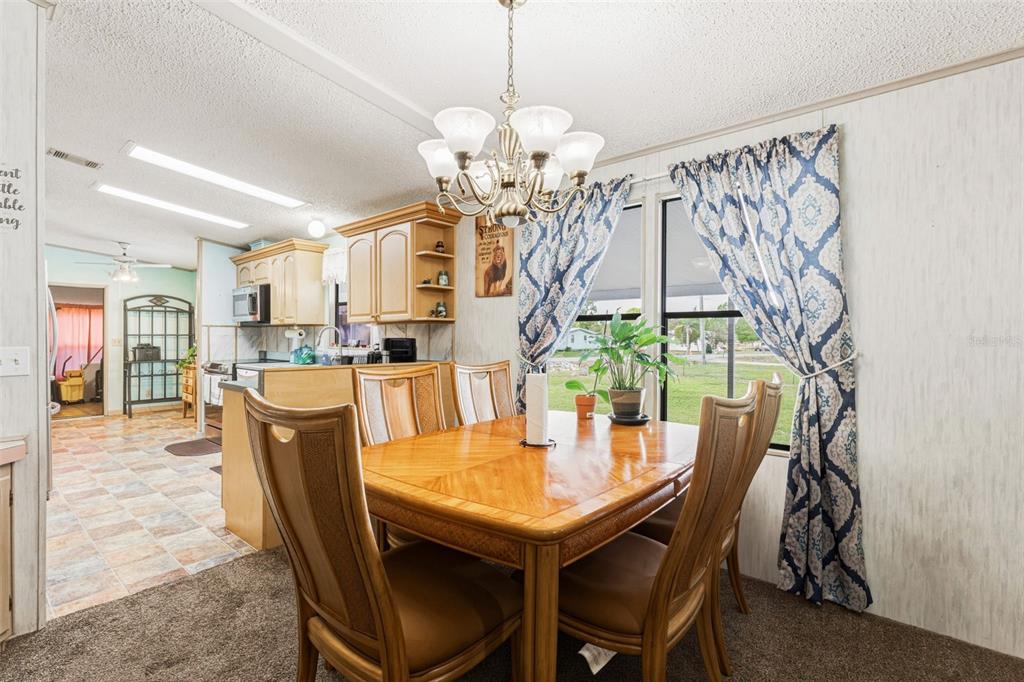 1586 Grapefruit Street Arcadia, FL 34266 - Photo 14 of 40 a dining room with furniture a chandelier and wooden floor