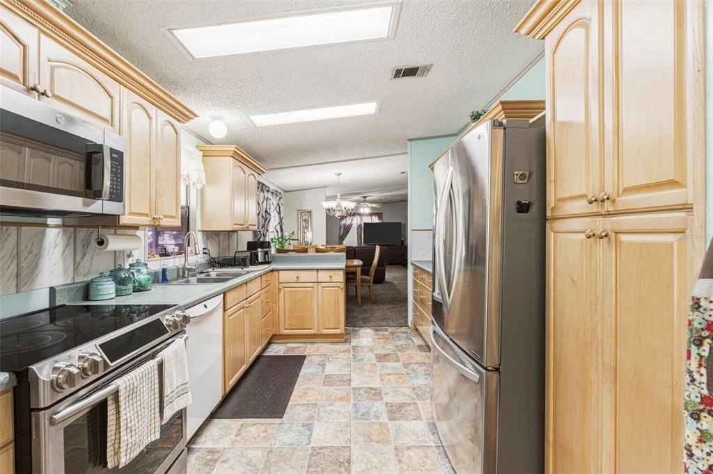 1586 Grapefruit Street Arcadia, FL 34266 - Photo 19 of 40 a kitchen with stainless steel appliances a refrigerator sink and cabinets