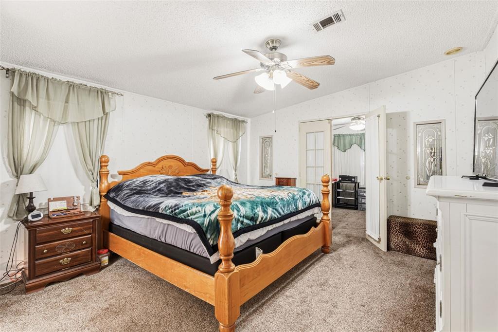 1586 Grapefruit Street Arcadia, FL 34266 - Photo 22 of 40 a bedroom with a bed and a chandelier