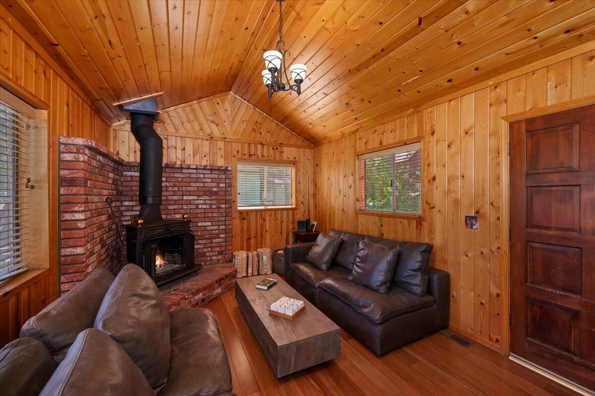 39187 Arapahoe Road Fawnskin, CA 92333 - Photo 7 of 33 a living room with furniture a fireplace and a flat screen tv