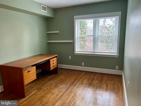 a hallway with white doors wooden floor and stairs