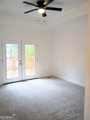 an empty room with windows and ceiling fan