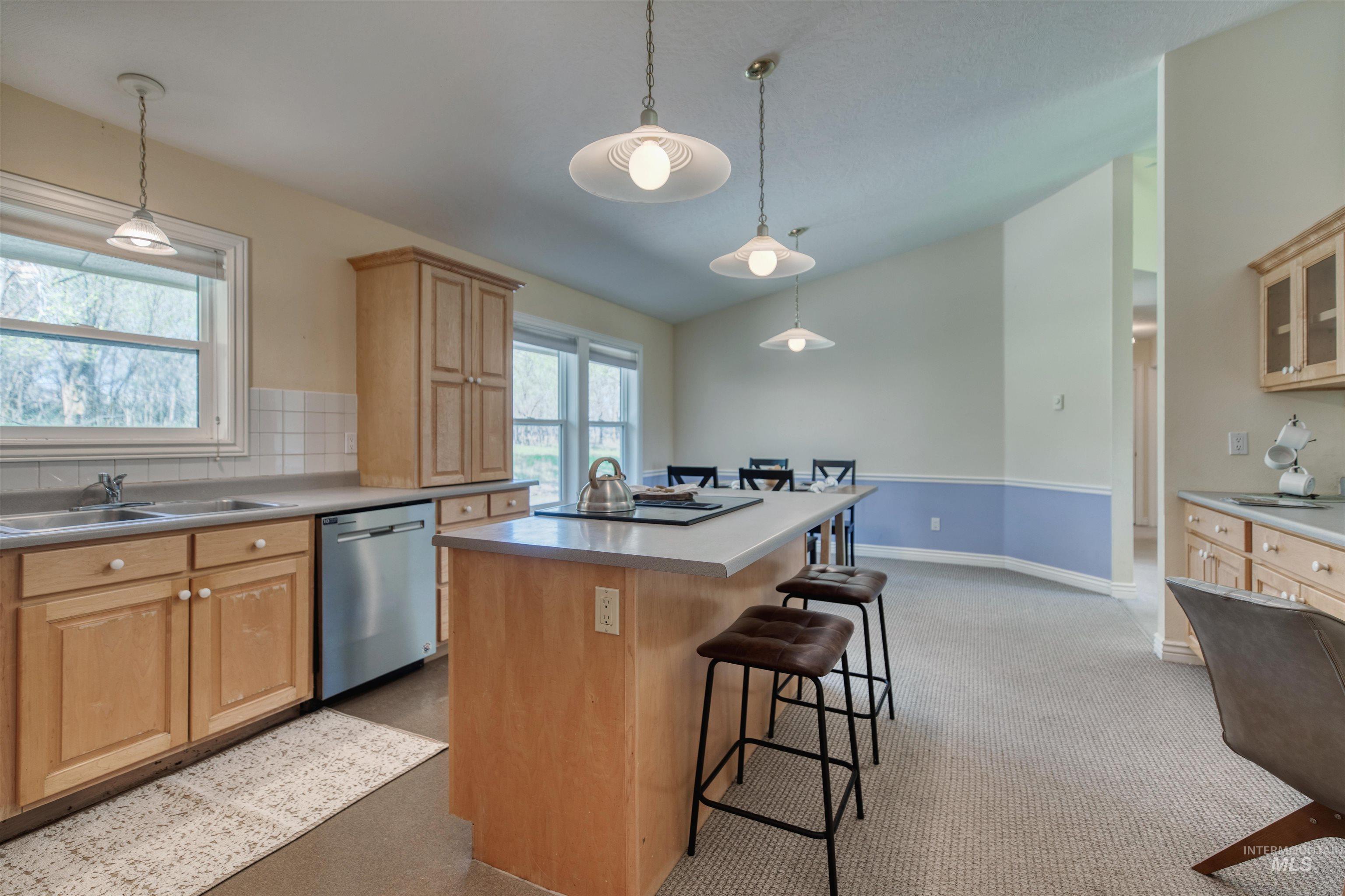 1295 15th Street Vale, OR 97918 - Photo 12 of 50 Kitchen with a kitchen island, stainless steel dishwasher, lofted ceiling, light countertops, and light wood finish cabinetry