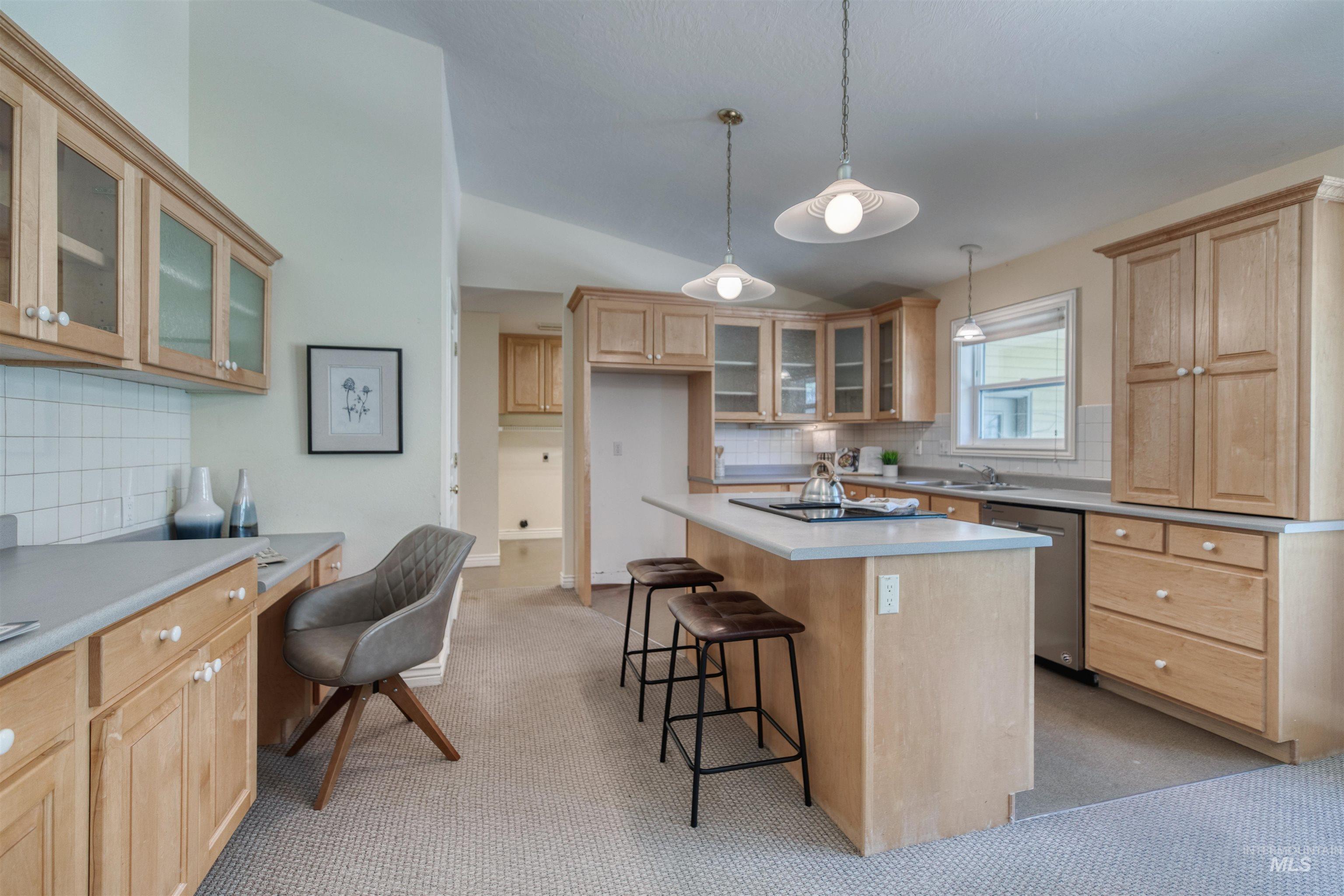 1295 15th Street Vale, OR 97918 - Photo 9 of 50 Kitchen featuring glass insert cabinets, backsplash, lofted ceiling, a kitchen island, and light countertops