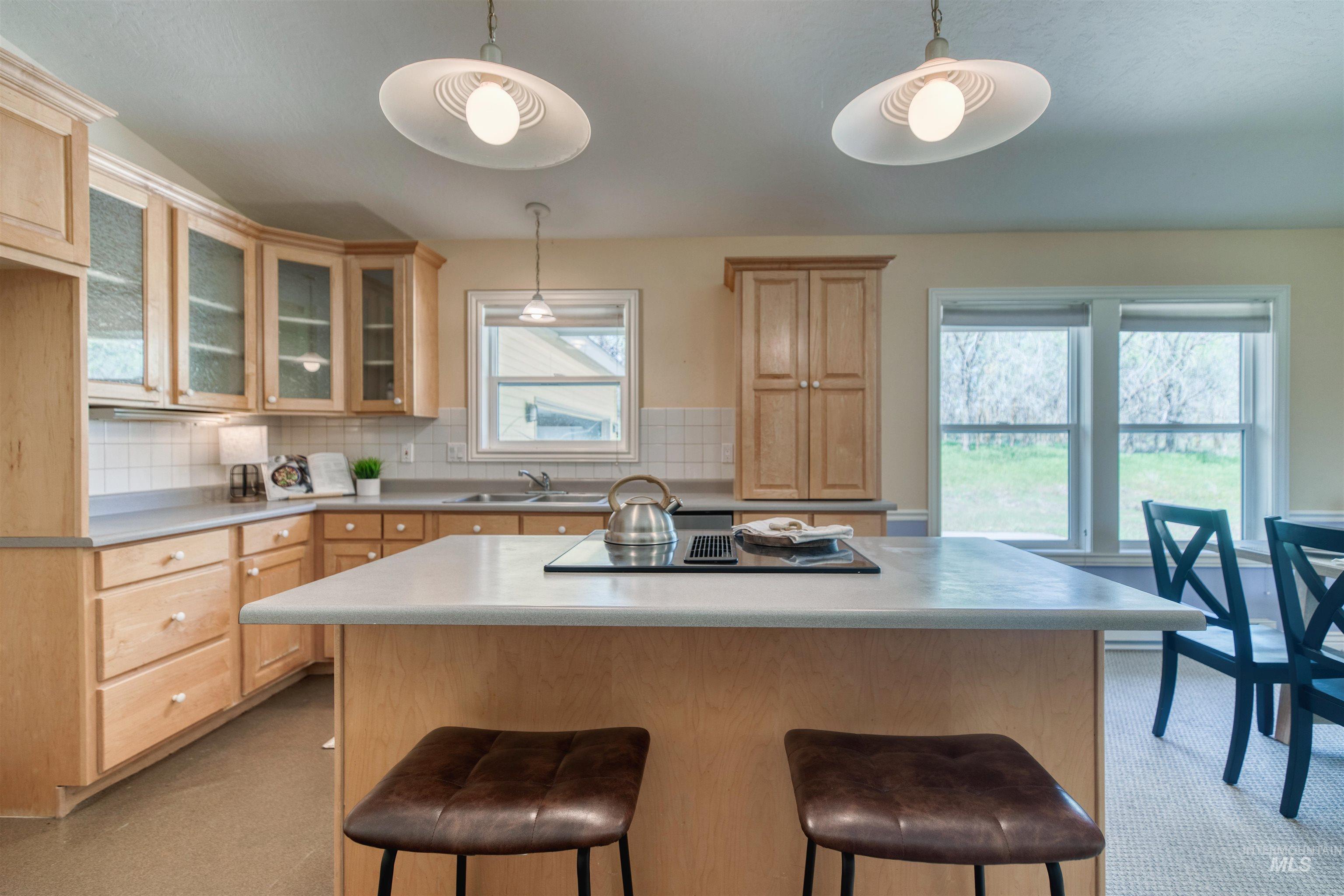 1295 15th Street Vale, OR 97918 - Photo 10 of 50 Kitchen with a kitchen island, light countertops, a breakfast bar area, and backsplash