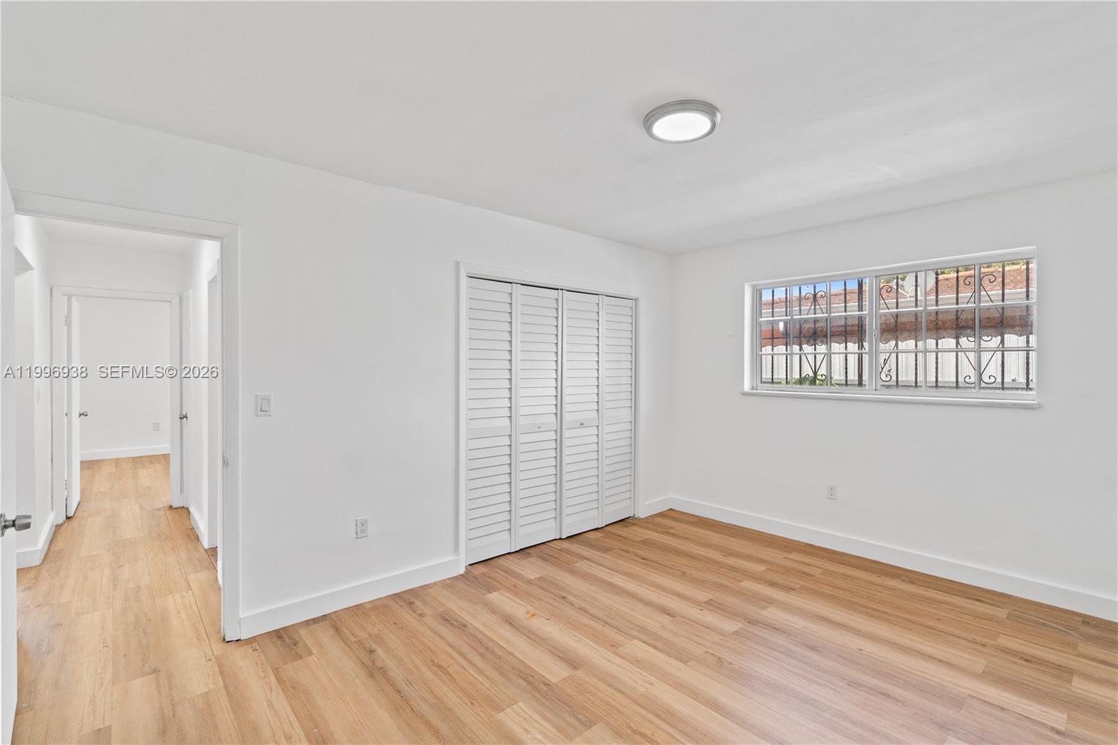 361 East 39th Street, Unit 1 Hialeah, FL 33013 - Photo 14 of 47 an empty room with wooden floor and windows