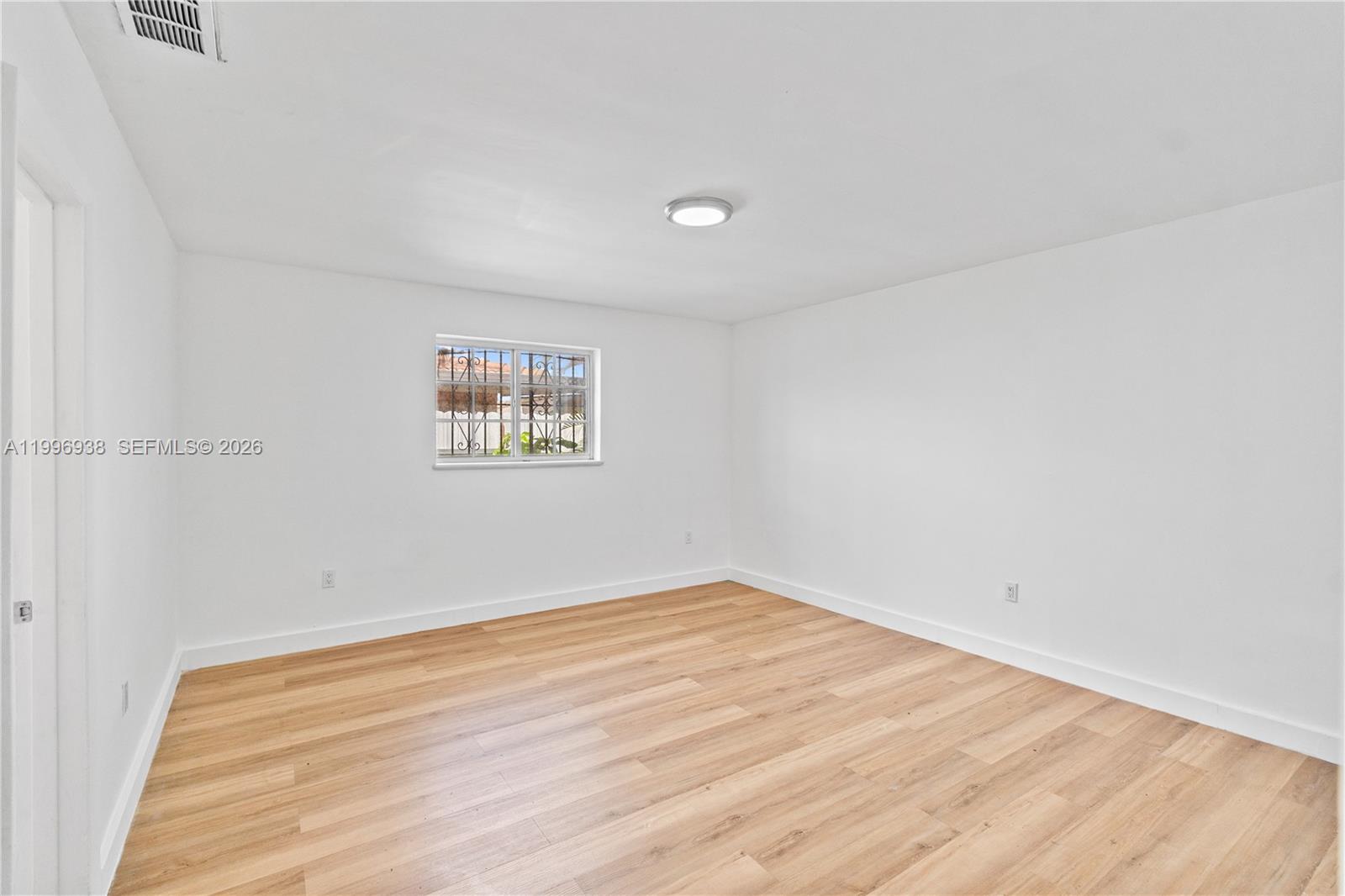 361 East 39th Street, Unit 1 Hialeah, FL 33013 - Photo 22 of 47 an empty room with wooden floor and windows