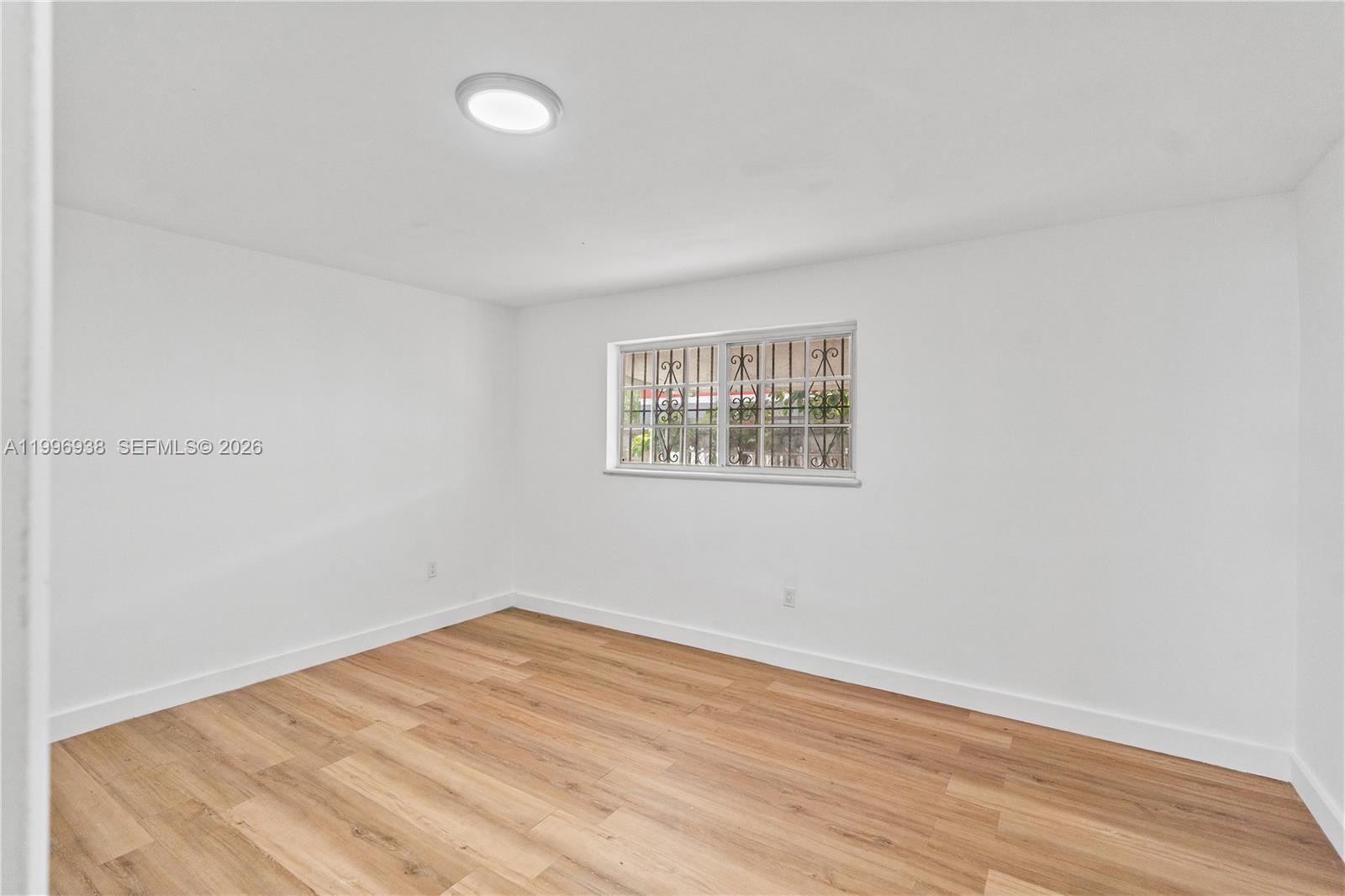 361 East 39th Street, Unit 1 Hialeah, FL 33013 - Photo 23 of 47 an empty room with wooden floor and windows