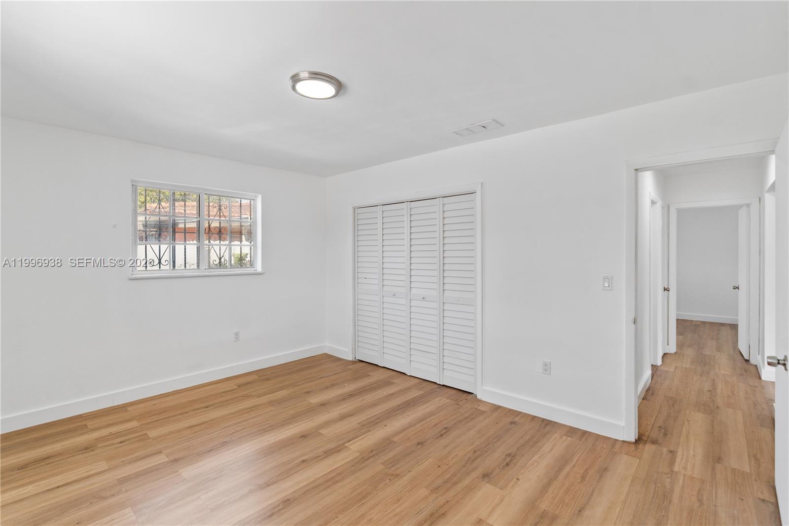 361 East 39th Street, Unit 1 Hialeah, FL 33013 - Photo 10 of 47 an empty room with wooden floor and windows